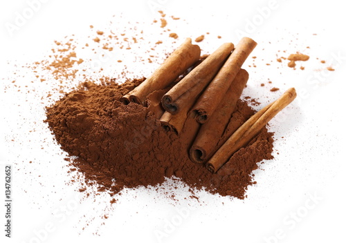 cinnamon sticks and pile cocoa powder isolated on white background