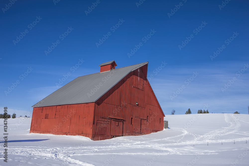 A red barn on the side of a small snowy hill in Moscow, Idaho. A red barn on the side of a small snowy hill in Moscow, Idaho.
