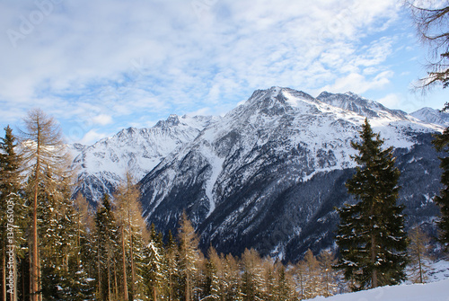 The mountain in the snow, sky with clouds, snow-covered spruce