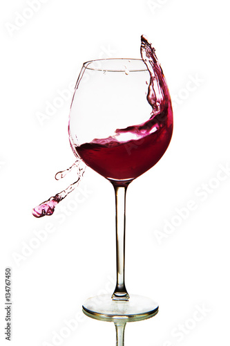 Red wine splashing in glass on a white background