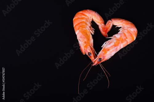 Two shrimps forming a heart in a black background
