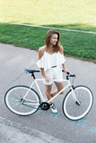 Beautiful girl with a bicycle in summer Park