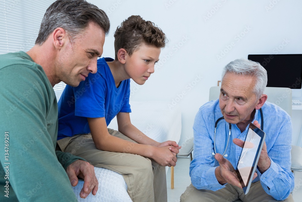 Fototapeta premium Doctor and patient discussing over digital tablet