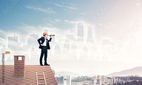 Engineer man standing on roof and looking in spyglass. Mixed med