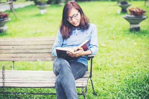 Hipster charming girl relaxing in the park while read book, Enjo