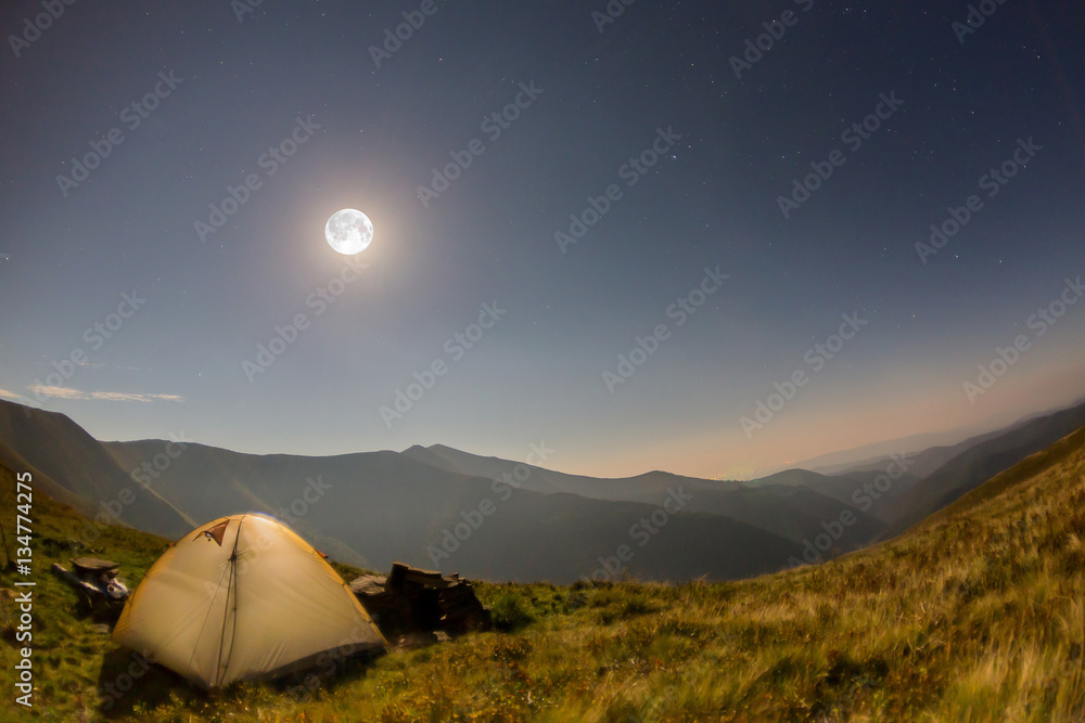 Tent at night on a background of mountains