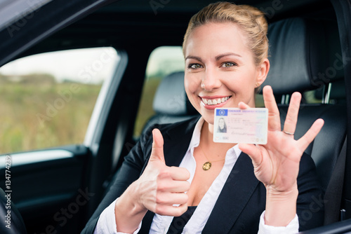 Canvas-taulu Woman showing driving license and thumbs up