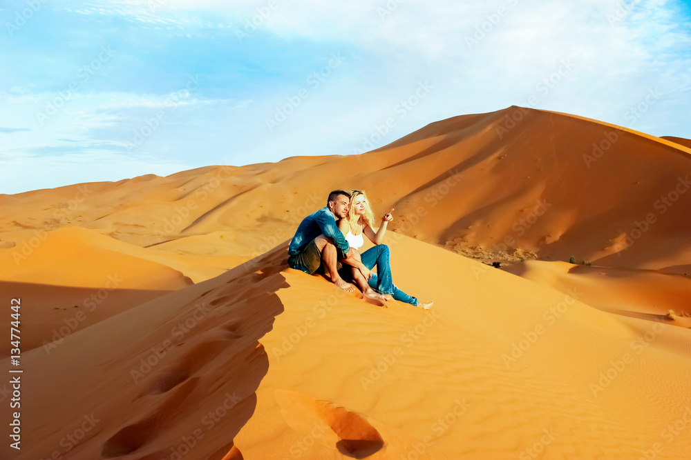 Loving couple in the Sahara Desert. Morocco. - obrazy, fototapety, plakaty 