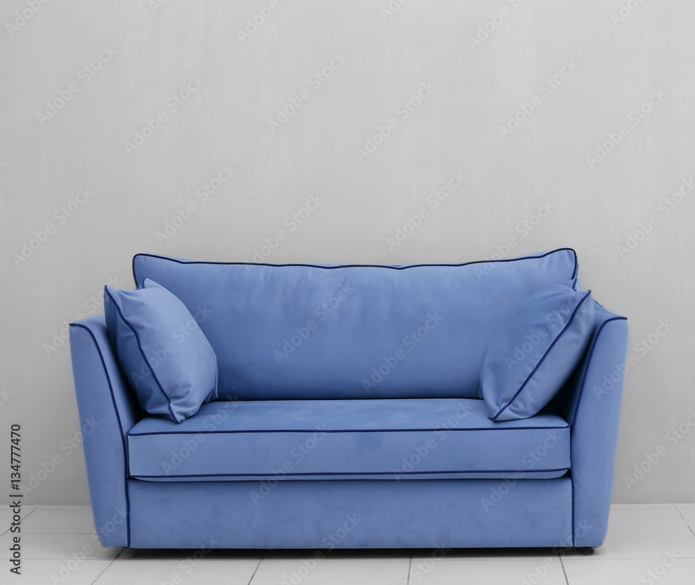 Fototapeta premium Modern couch on light wall background