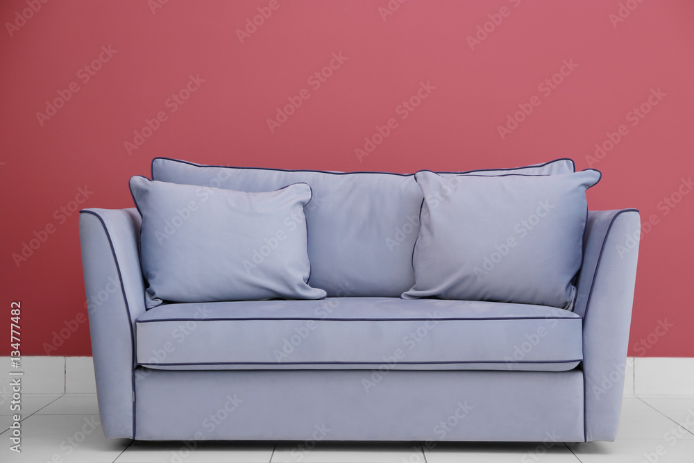 Fototapeta premium Modern couch on red wall background