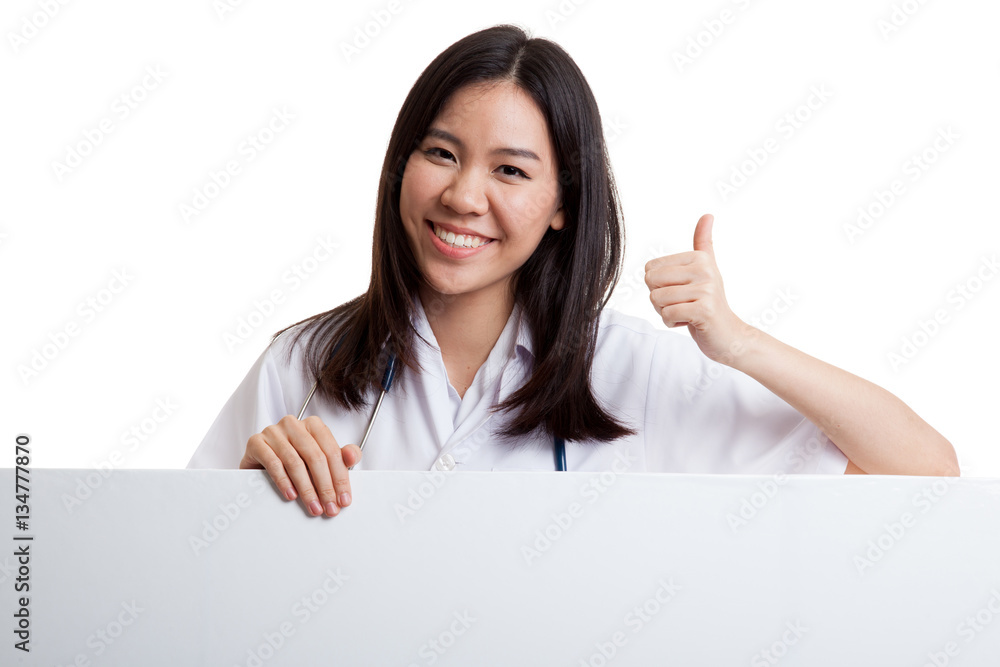Young Asian female doctor show thumbs up behind blank white bil Young Asian female doctor show thumbs up behind blank white bil