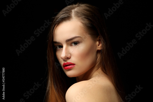 Portrait of beautiful young woman on black background