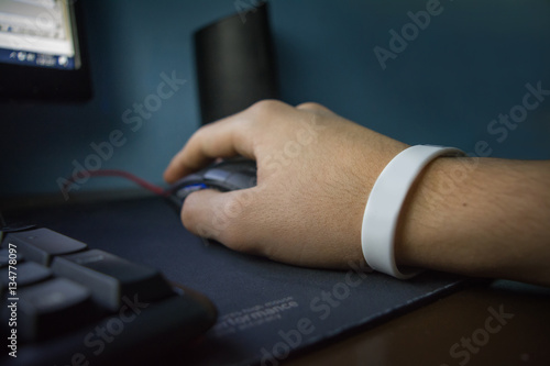 Male hands with bracelet holding mouse