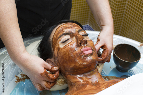Process chocolate mask Woman in a beauty salon