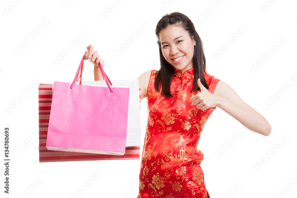 Asian girl in chinese cheongsam dress with shopping bag. Asian girl in chinese cheongsam dress with shopping bag.