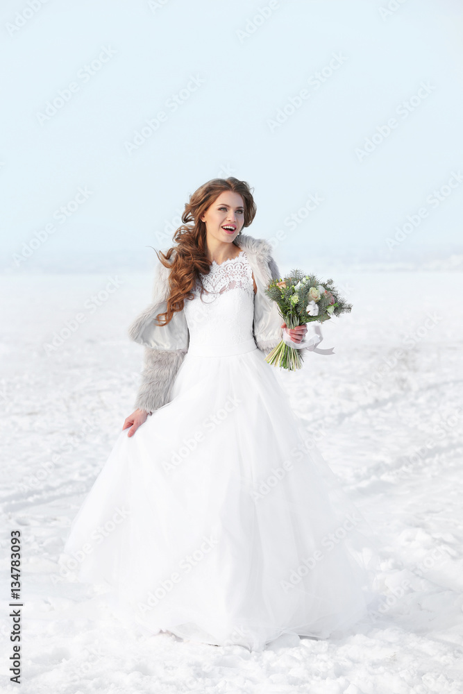 Beautiful bride with bouquet outdoors on winter day