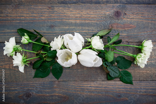 Valentines Day background. Floral pattern made white flowers  green leaves  branches on wood background. Flat lay  top view. Valentine s background