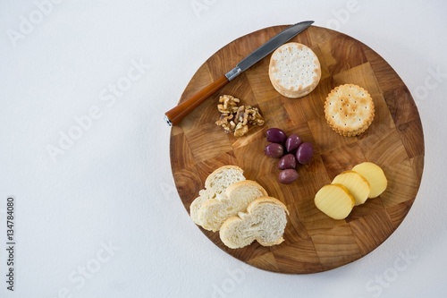 Bread, crackers, olives, walnut and knife
