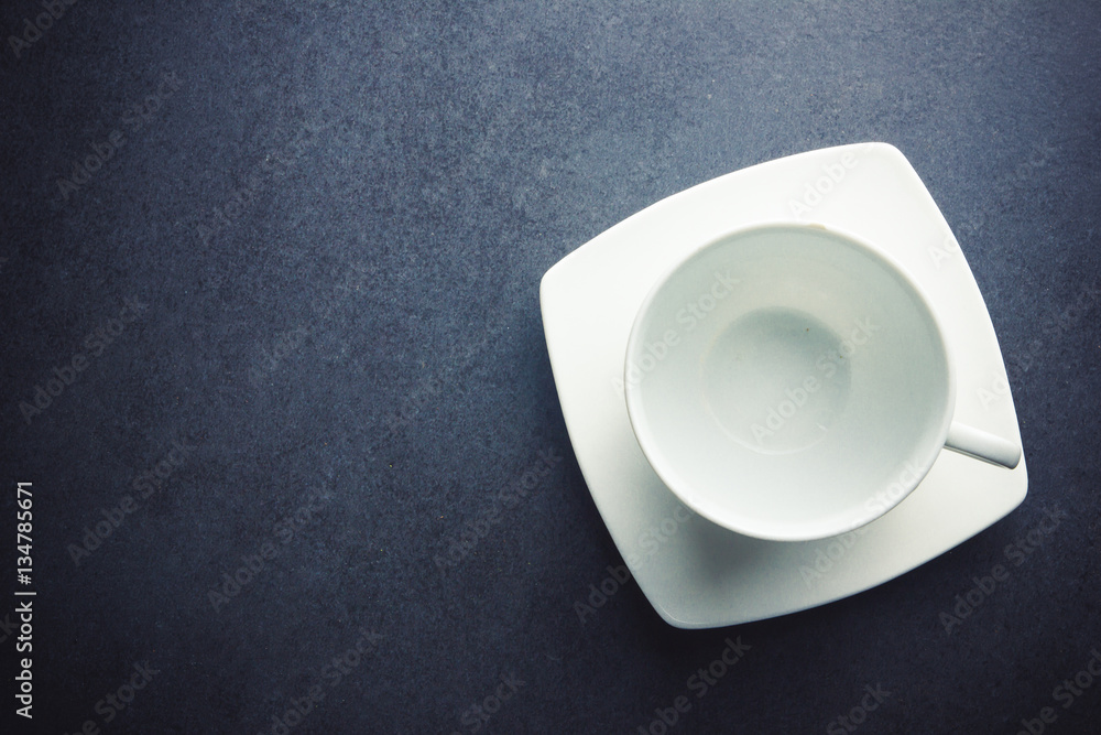 Empty white coffee cup on black empty surface. Empty white coffee cup on black empty surface.