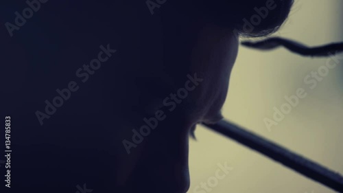 young man in twilight looks at the camera sadly