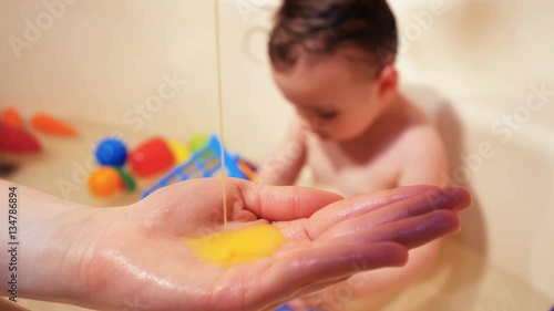 Baby wash in the bath. Use soap, shampoo for children. photo