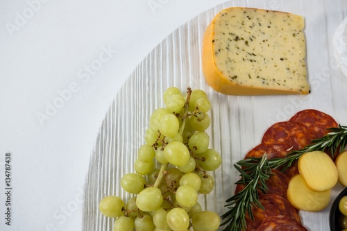 Fototapeta Naklejka Na Ścianę i Meble -  Cheese with grapes and salami on wooden board