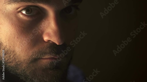 serious and charming man looks up at the camera