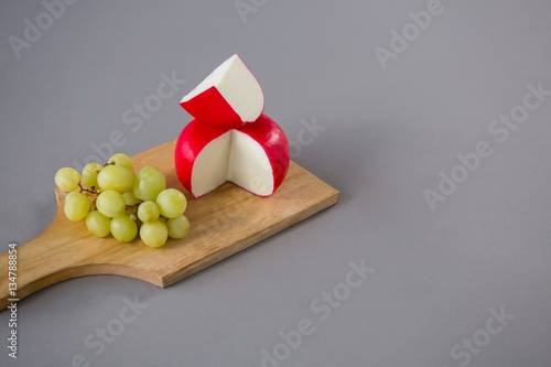 Cuadro en lienzo Gouda cheese with grapes on chopping board