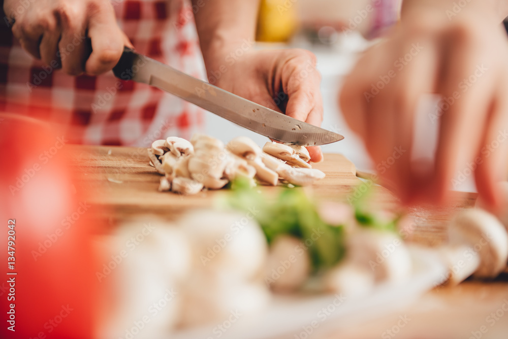 Obraz premium Woman slicing mushroom