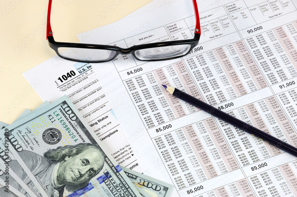tax calculation forms with pencil, eye glasses and USD dollar cash tax calculation forms with pencil, eye glasses and USD dollar cash