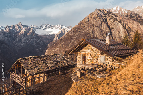 Old stone chalets with mountains in the background