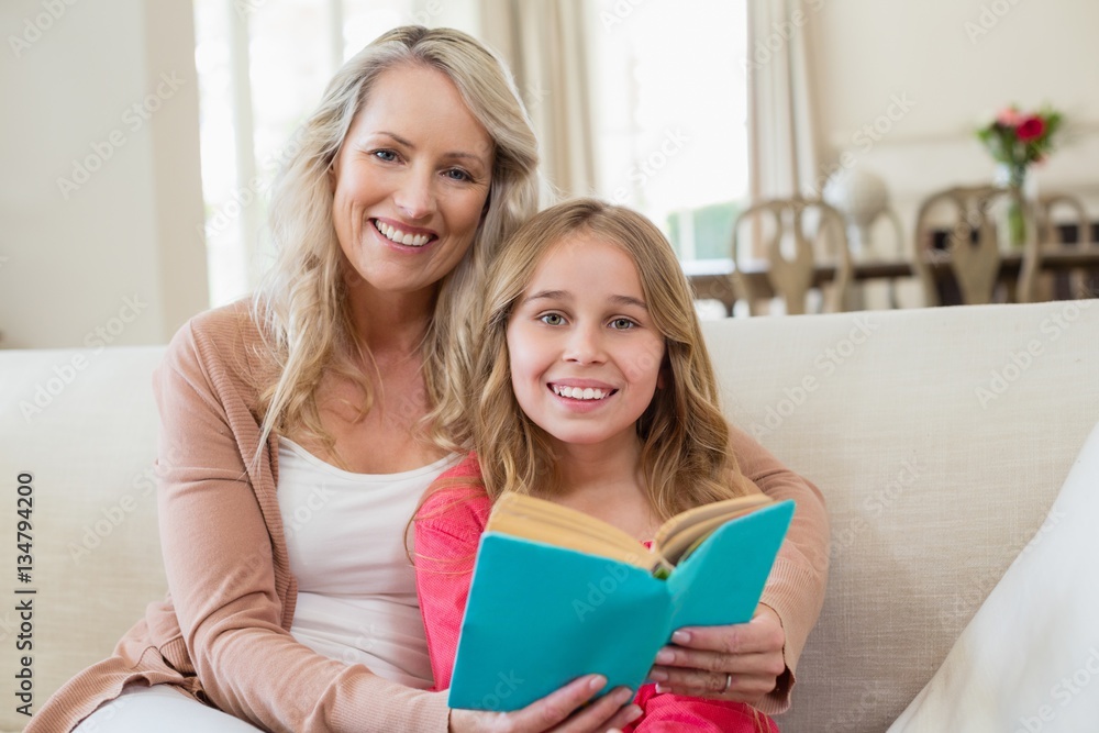 Mother and daughter reading a novel on the couch Mother and daughter reading a novel on the couch