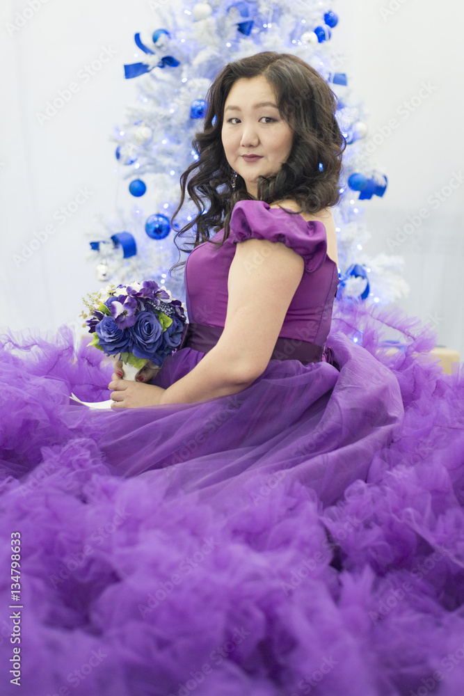 Full Asian woman in a lush lilac dress.