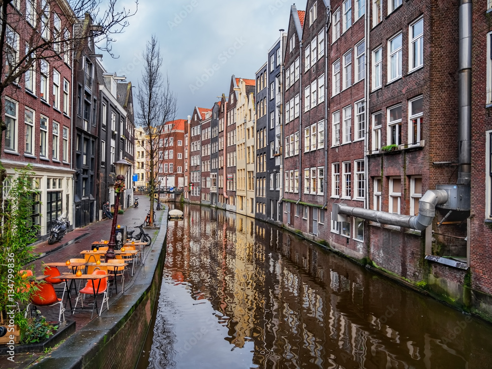 Colorful Amsterdam canal with traditional buildings and street c