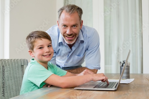 Father and son using laptop at desk © WavebreakMediaMicro
