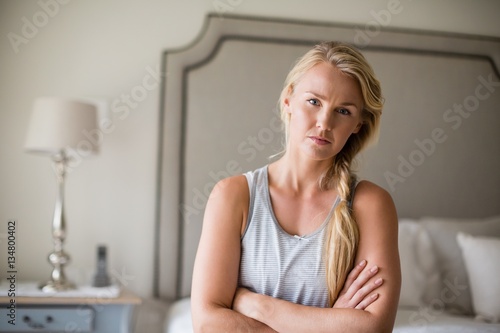 Beautiful woman sitting on bed with arms crossed in bedroom © WavebreakMediaMicro