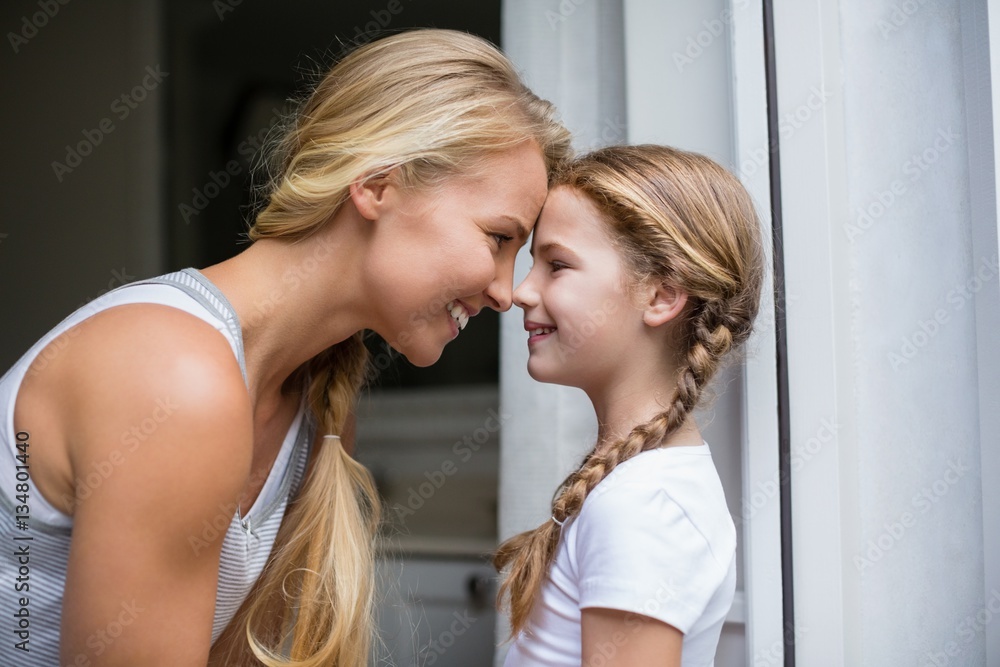 Smiling mother and daughter looking face to face Smiling mother and daughter looking face to face