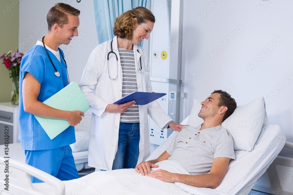 Obraz premium Doctors talking to patient in hospital bed