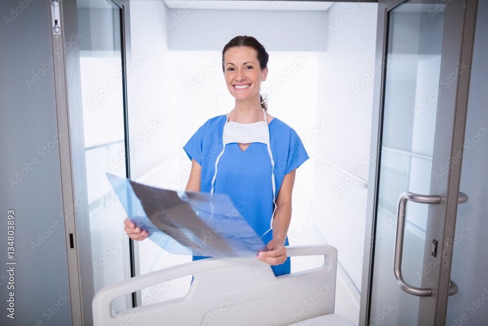 Portrait of doctor standing with x-ray report Portrait of doctor standing with x-ray report