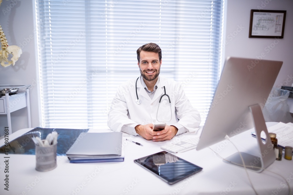 Portrait of male doctor sitting at desk Portrait of male doctor sitting at desk