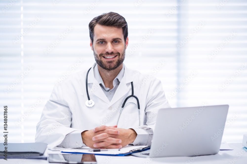 Portrait of male doctor sitting at desk Portrait of male doctor sitting at desk