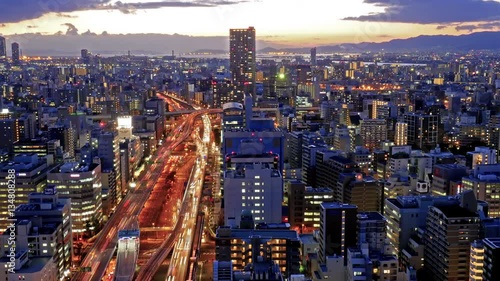 Time-lapse of Osaka traffic car trails and illuminated building

