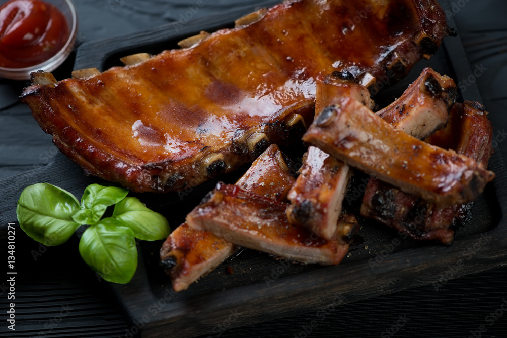 Close-up of whole and sliced baked pork ribs, selective focus