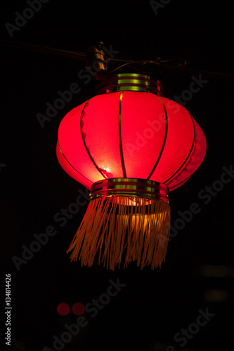 Happy chinese new year concept: traditional red paper lanterns hanging. Illuminated street decorations lightning in the night. © yolya_ilyasova