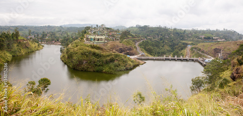Dam on a river and houses on a hill in Sri lanka
