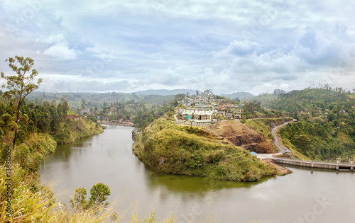 Dam on a river and houses on a hill in Sri lanka