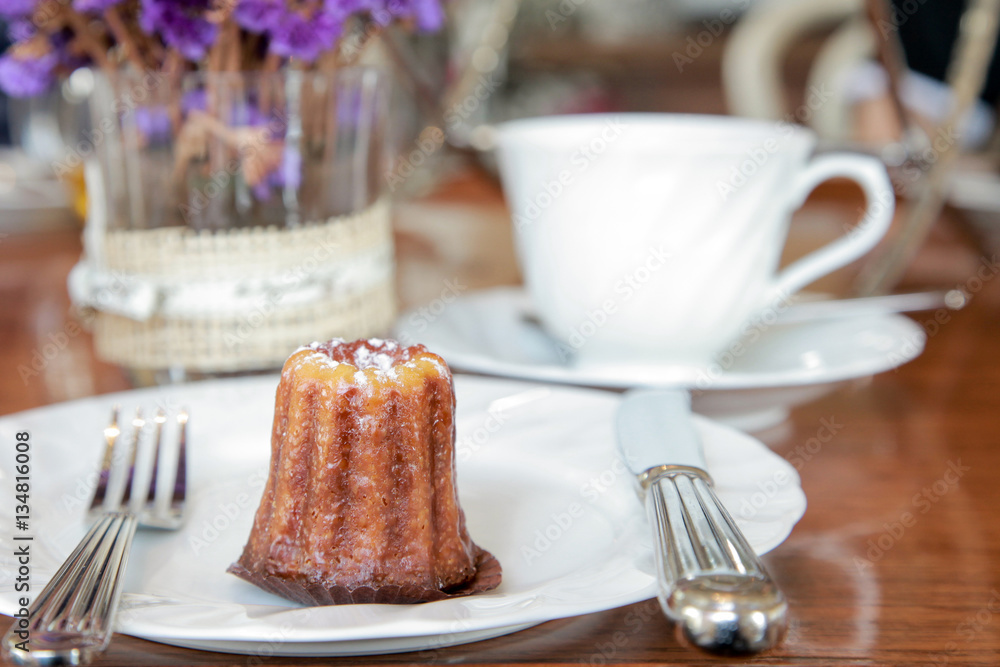 Small piece of canele serve in a plate on the table in tea shop