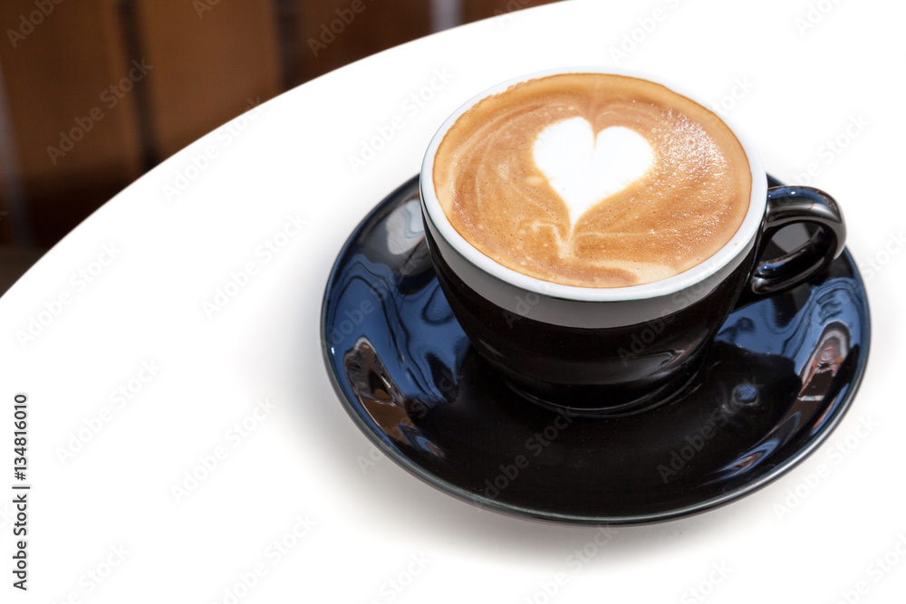 Coffee cup of heart shape latte art on the table in coffee shop