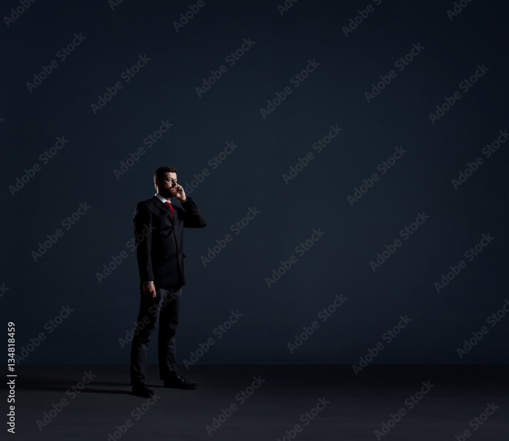 Businessman with a smartphone on black