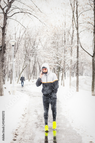 Jogger using cellphone in cold weather.